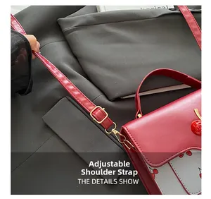 Detail view of adjustable red leather shoulder strap with golden metal buckle