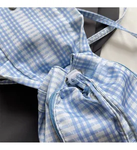 Detail of blue plaid backpack featuring drawstring closure and textured woven fabric