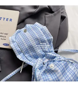 Detail of blue checkered backpack featuring secure magnetic buckle and drawstring closure