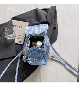 Internal storage view of blue plaid lace drawstring backpack with essentials inside