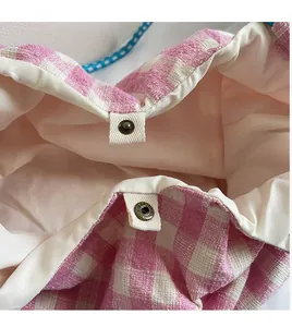 Detail of pink gingham canvas tote bag showing secure metal snap button closure
