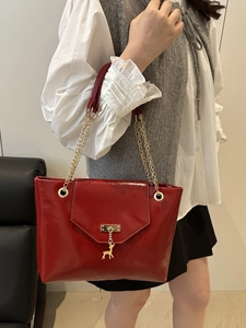 Elegant red patent leather tote bag with gold chain straps and a deer charm pendant