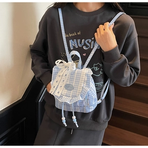 Dettaglio mini zaino a quadretti blu con fiocco in pizzo e cordoncino regolabile