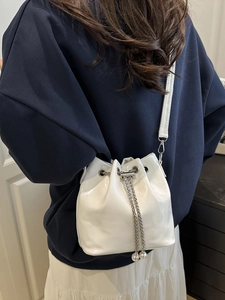 Minimalist white patent leather bucket bag with silver chain drawstring and pearl charms