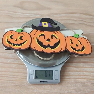 Detailed view of Halloween pumpkin wood hanging decoration weighing 81.1g on a scale