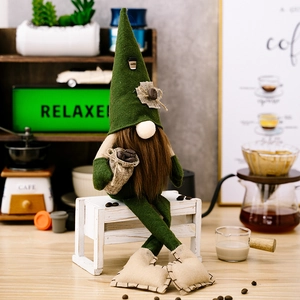 Detail eines Kaffee-Gnomes mit langen Beinen und einem Kaffeesack auf einem weißen Hocker