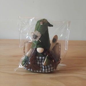 Detail eines Kaffee-Gnomes mit grünem Hut, geflochtenem Haar und Holzlöffel-Accessoire
