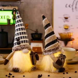 Lighted coffee gnomes with striped knit hats and coffee bean decor on a warm wooden desk