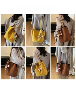 Detail view of large faux suede tote bag in brown and yellow with cute dog pendant