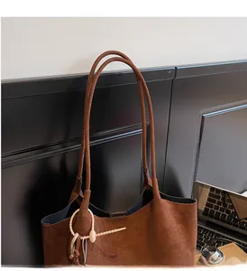 Detail view of brown faux suede tote bag featuring slim straps and a matte finish texture