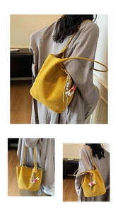 Detail of yellow faux suede tote bag featuring a cute animal charm and spacious design