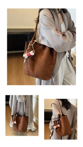 Detail of vintage brown suede tote bag with a cute plush animal charm accessory