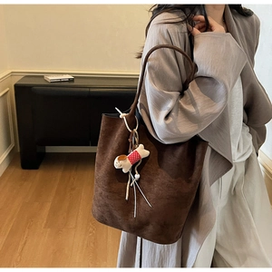 Brown suede tote bag detail with minimalist cut and cute polka dot dog charm accessory
