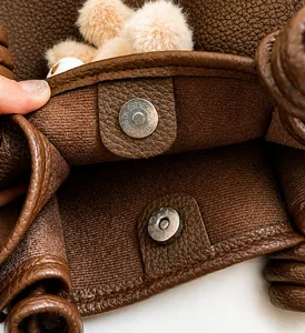 Close-up of the silver magnetic closure on a brown pebble leather tote bag with soft lining