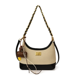 Beige canvas and black leather hobo bag with gold chain strap and pendant detail