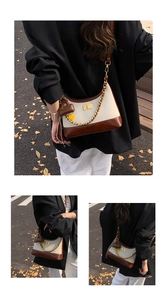 Detail of retro half-moon bag featuring beige canvas, brown leather and gold chain strap