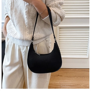 Detail of black crescent shoulder bag with lychee texture and metal zipper closure