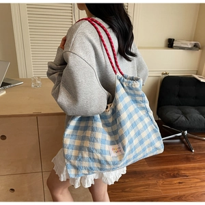 Détail du grand sac cabas en toile à carreaux bleus et blancs avec poignées en corde rouge