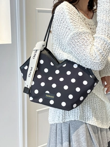 Women's black polka dot tote bag with V-shaped opening and decorative ribbon