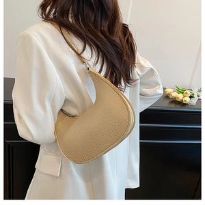 Close-up of champagne lychee pattern leather crescent bag on female model shoulder