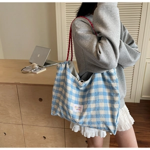 Détail du sac cabas à carreaux bleu et blanc avec anses contrastées en corde tressée rouge