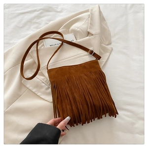 Détail du sac bandoulière en daim marron caramel avec des franges bohèmes rétro