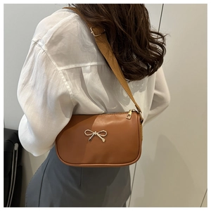 Détail d'un sac à bandoulière marron rétro avec boucle dorée et sangle en toile