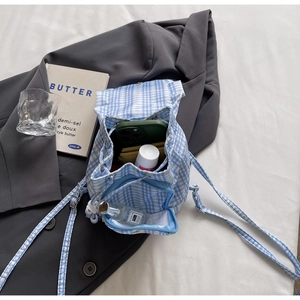 Dettaglio mini zaino a quadretti azzurro con chiusura a coulisse e tasca con cerniera
