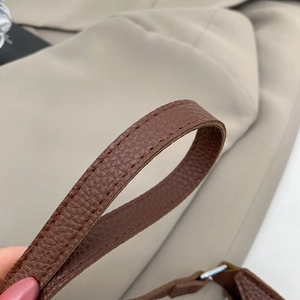 Close-up of deep brown litchi pattern leather shoulder strap with double-stitched edges