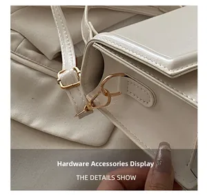 Detailed close-up of premium light gold hardware hooks on white leather shoulder bag