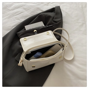 Detail view of the cream shoulder bag interior showing multiple storage compartments