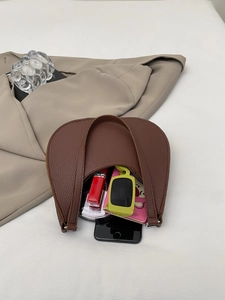 Macro view of brown lychee grain leather handbag showing spacious interior for essentials