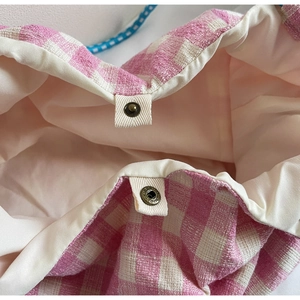 Detailed macro view of pink gingham woven tote bag showing magnetic clasp and pink lining