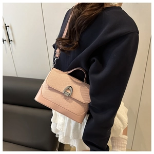 Pink crossbody bag with woven texture lid and silver buckle worn by a model