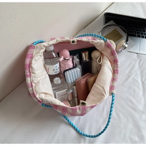 Detail of checkered tote bag interior capacity with magnetic snap and woven handle