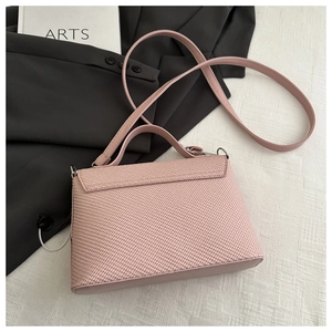 Close-up of pink handbag with woven texture detail and stylish top handle on white surface