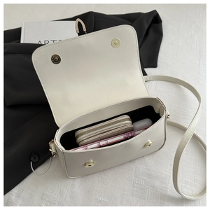 Detail view of the open crossbody bag showing spacious interior and black fabric lining