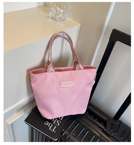 Detailansicht der pinkfarbenen Nylon-Tragetasche mit Fashion-Patch und Metallic-Griffen