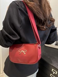 Fashionable red crossbody handbag for women with golden bow detail and wide shoulder strap