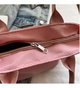 Detail der rosa Tasche mit glattem silbernem Metallreißverschluss und Nylonstruktur