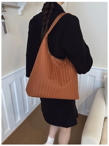 Détail du grand sac hobo marron tressé avec texture en cuir à motif en V