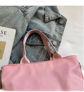 Detailansicht der rosa wasserfesten Nylon-Handtasche mit Fashion-Etikett und Tragegriff