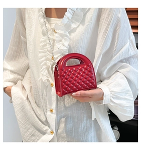 Detail of red quilted mini bag with silver chain strap and hollow circular handle