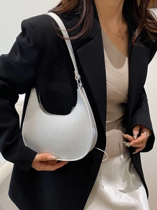 Silver crescent hobo shoulder bag with textured metallic finish on a female model