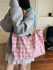 Pink and white checkered tote bag with woven shoulder straps in a minimalist casual style