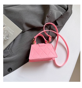 Detail of vibrant pink quilted mini handbag with gold hardware and top handle on blazer
