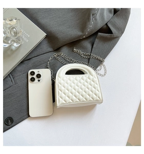 Close-up of white quilted leather mini bag with silver chain and cutout handle detail