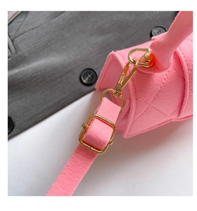Detail of pink quilted felt handbag showing gold lobster clasp and adjustable shoulder strap
