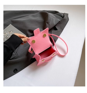 Macro detail of pink crocodile-texture mini bag with golden magnetic snap closures