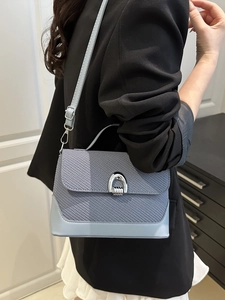 Light blue woven texture handbag with silver horseshoe buckle and adjustable shoulder strap